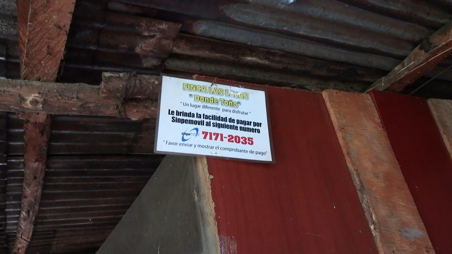 Cartel interior del restaurante Finca Las Lajas Donde Toño en Alajuelita con información de pago Sinpemóvil — escena fotografiada durante reconstrucción judicial de hechos — doble homicidio adultos mayores Costa Rica 2025