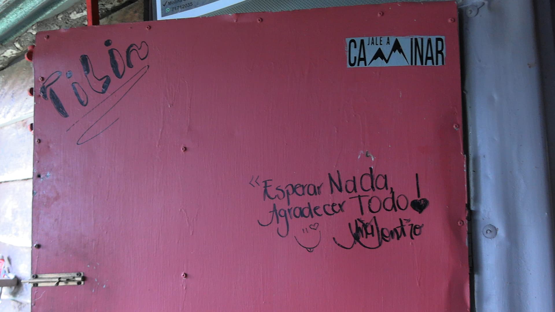 Puerta roja del restaurante Finca Lajas Donde Toño en Alajuelita con mensajes escritos por visitantes — «Esperar Nada Agradecer Todo» — fotografiada durante reconstrucción de hechos caso doble homicidio Costa Rica mayo 2026