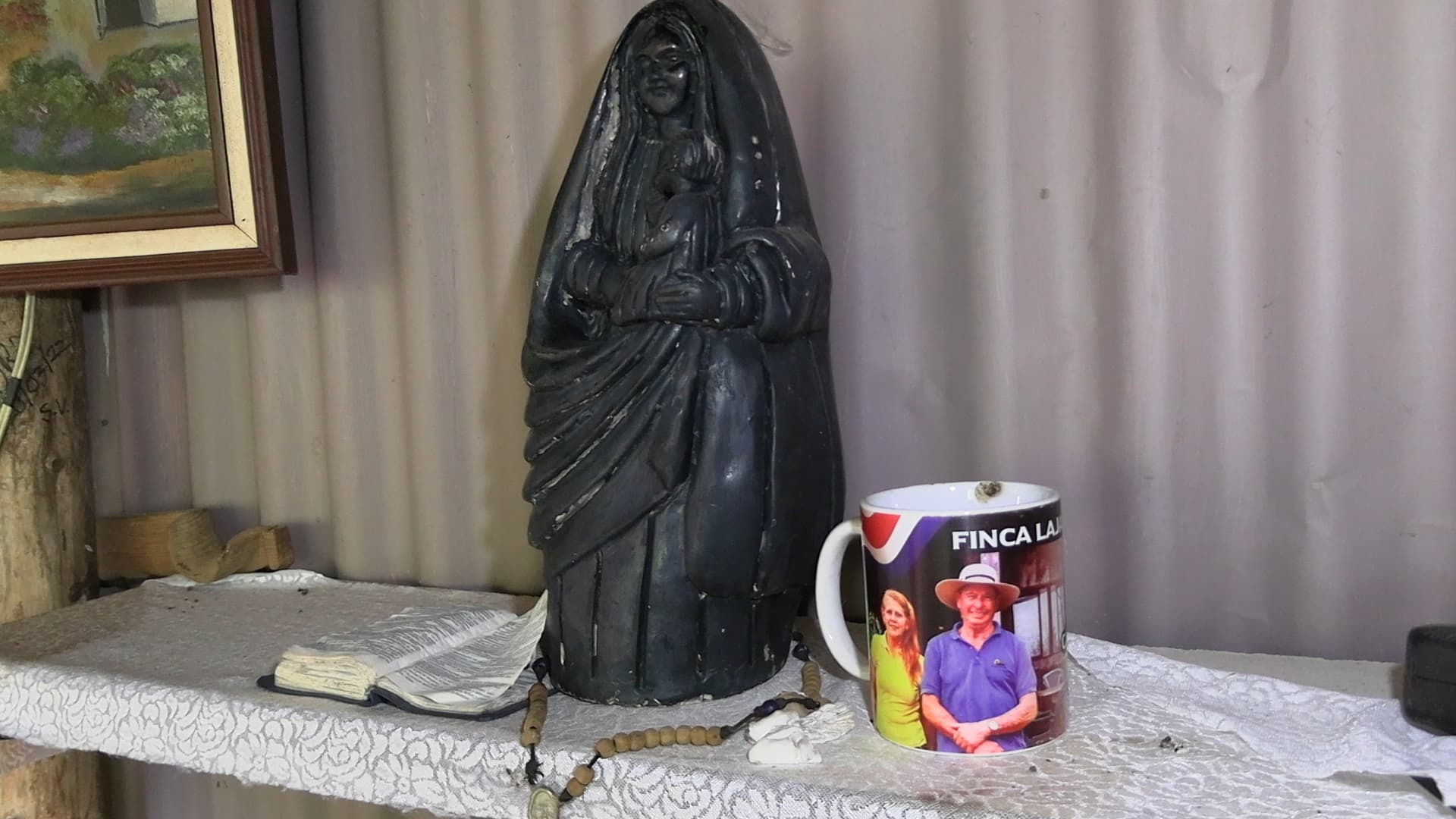 Taza personalizada del restaurante Finca Lajas con fotografía de Antonio Toño Badilla y Maureen Molina junto a imagen religiosa — objetos personales hallados durante reconstrucción de hechos caso doble homicidio Alajuelita Costa Rica 2025